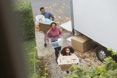 משפחה עוברת לגור בבית חדש, נושאת ארגזים ממכונית טנדר