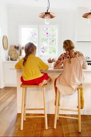 שתי ילדות עושות שיעורי בית באי המטבח