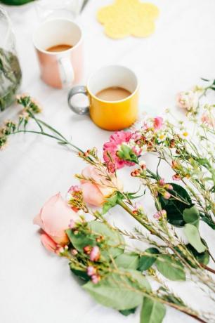 שולחן עם פרחים חתוכים וכוסות קפה בבית המלאכה לסידור פרחים