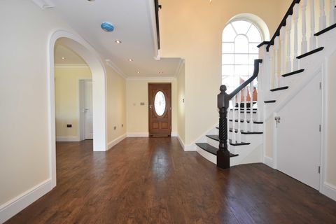 מדרגות ודלתות מקושתות באולם הכניסה לבית עם רצפות עץ