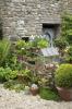 גן החצר מתגאה בקירות אבן, צמחים ריחניים ועציץ ירוקים